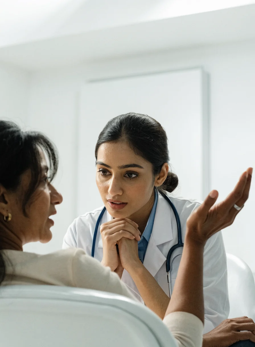 A doctor listening to a seated patient